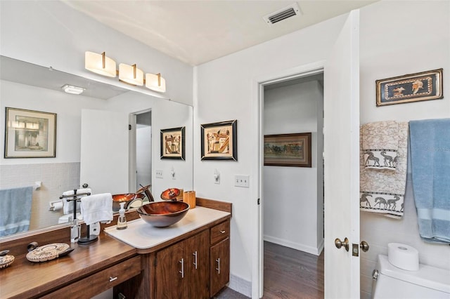 bathroom featuring toilet, vanity, and hardwood / wood-style floors