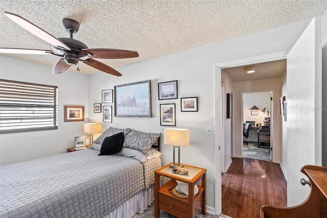 bedroom featuring a textured ceiling, ceiling fan, and dark hardwood / wood-style flooring