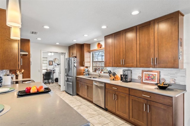 12 Bannerwood Ln, Palm Coast, FL 32137 - kitchen with stainless steel appliances, tasteful backsplash, light countertops, recessed lighting, and brown cabinetry