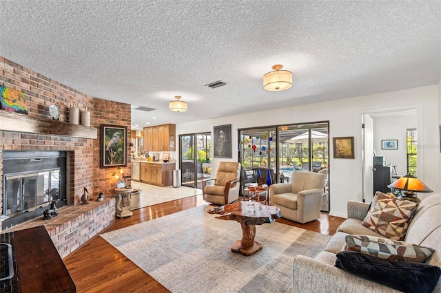 12 Bannerwood Ln, Palm Coast, FL 32137 - living room featuring light wood-style flooring, a fireplace, and a textured ceiling