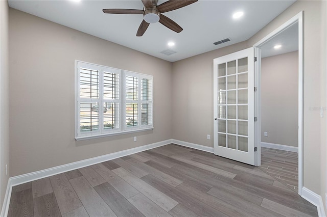 empty room featuring visible vents, light wood-style flooring, and baseboards