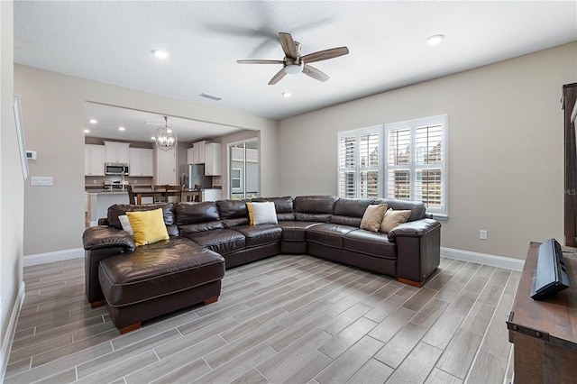 living area with wood finish floors, visible vents, and baseboards