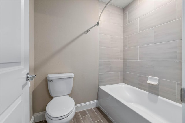 full bath featuring toilet, wood tiled floor, baseboards, and shower / bathtub combination