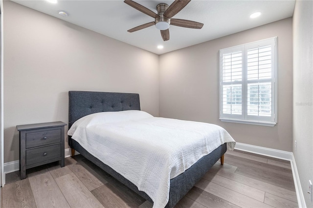 bedroom featuring ceiling fan, baseboards, wood finished floors, and recessed lighting