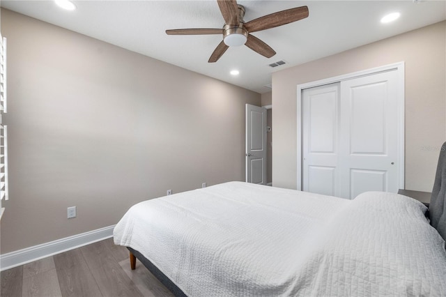 bedroom featuring baseboards, visible vents, dark wood finished floors, a closet, and recessed lighting