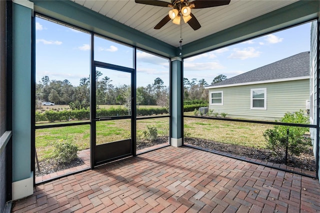 unfurnished sunroom featuring ceiling fan