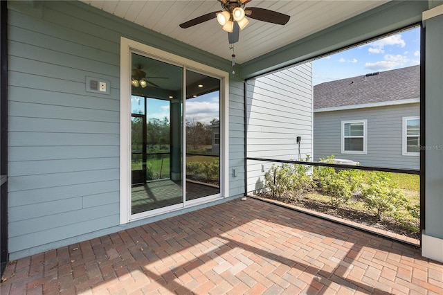 unfurnished sunroom with ceiling fan