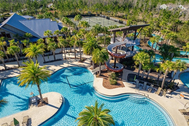 community pool featuring a water slide and a patio area