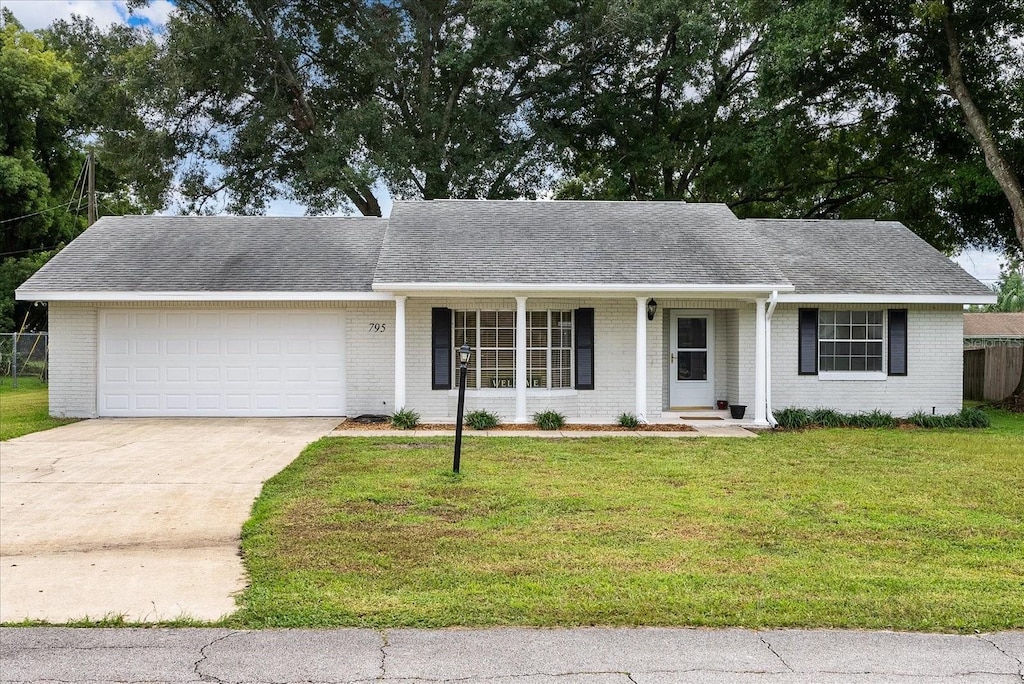 single story home with a garage and a front lawn