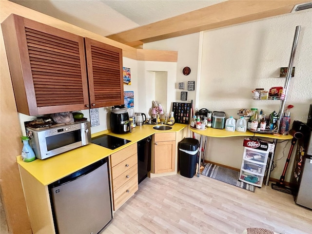 kitchen featuring light wood-type flooring, appliances with stainless steel finishes, sink, and light brown cabinets