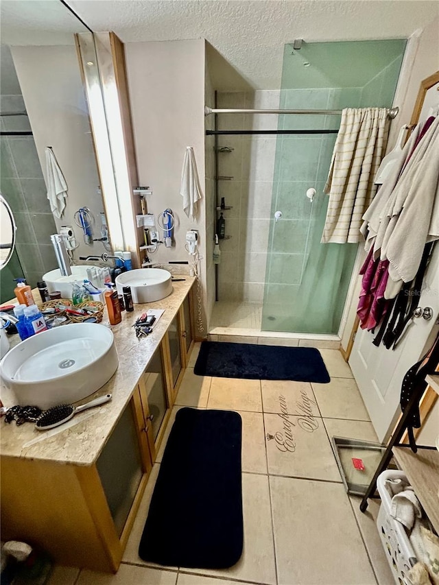 bathroom featuring a textured ceiling, a shower with door, tile patterned flooring, and vanity