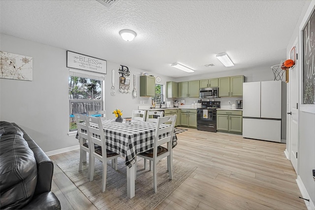 dining area with light wood-type flooring and a textured ceiling