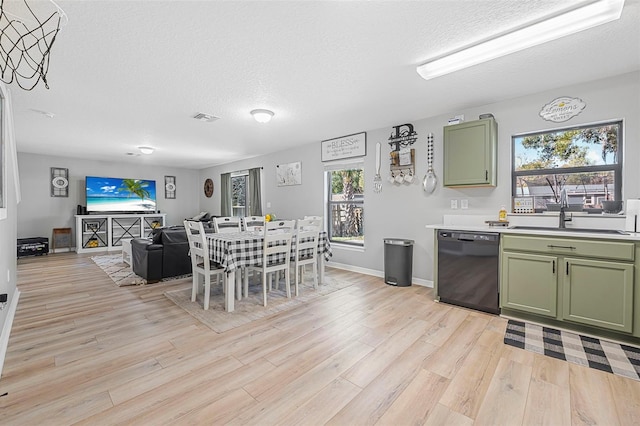 dining area with light hardwood / wood-style floors, sink, and a textured ceiling