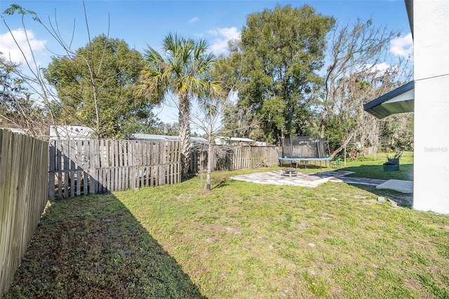 view of yard featuring a trampoline and a patio