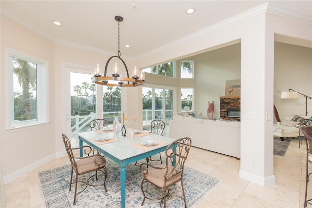 tiled dining area featuring crown molding, a wealth of natural light, a fireplace, and a chandelier