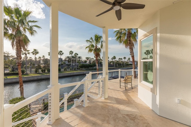 view of patio with ceiling fan and a water view