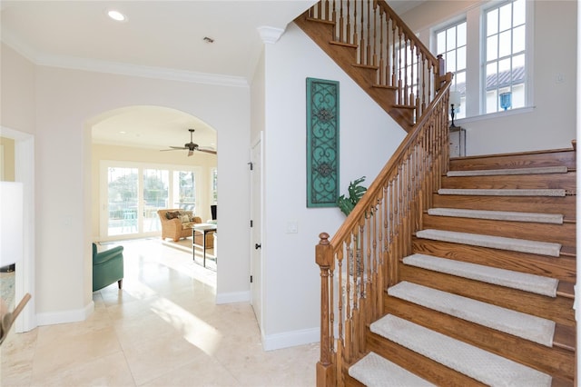 staircase with crown molding and ceiling fan