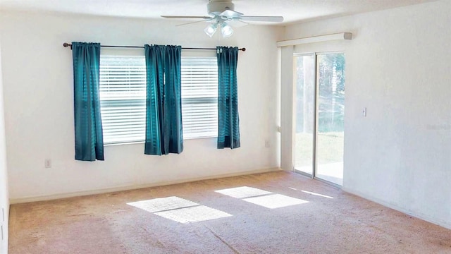 carpeted spare room featuring ceiling fan