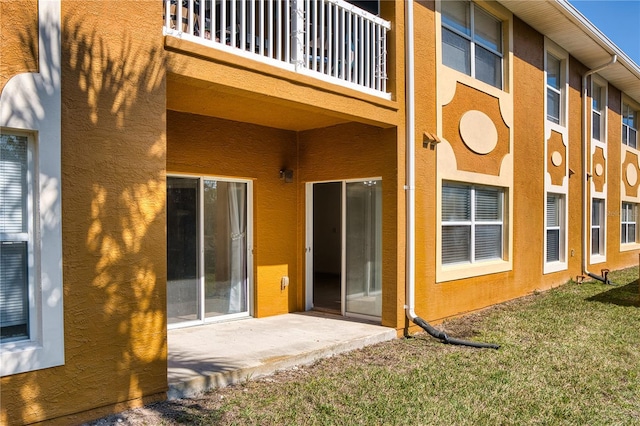 back of property with a patio area and a lawn