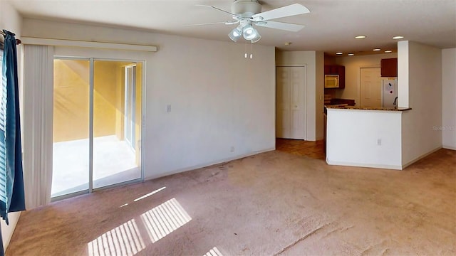 unfurnished living room featuring light colored carpet and ceiling fan