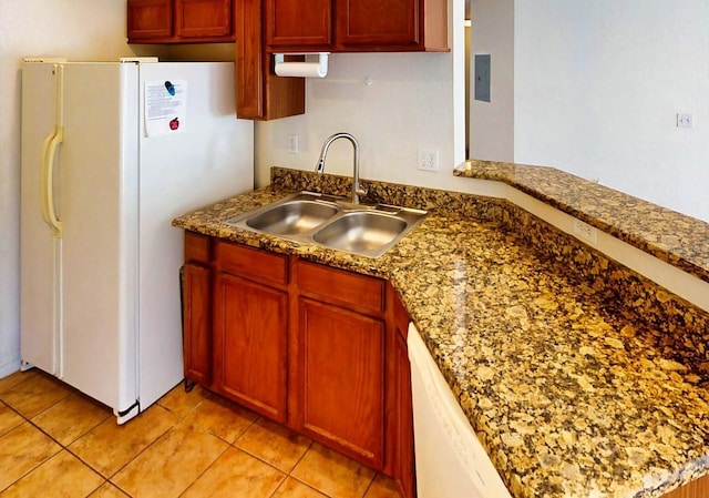 kitchen featuring stone counters, sink, light tile patterned floors, kitchen peninsula, and white appliances