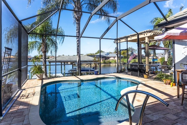 pool with glass enclosure, a water view, and a patio