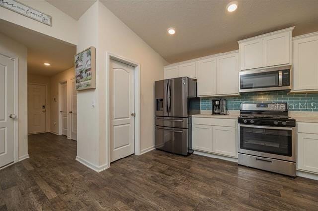 kitchen featuring white cabinetry, appliances with stainless steel finishes, dark hardwood / wood-style floors, and backsplash