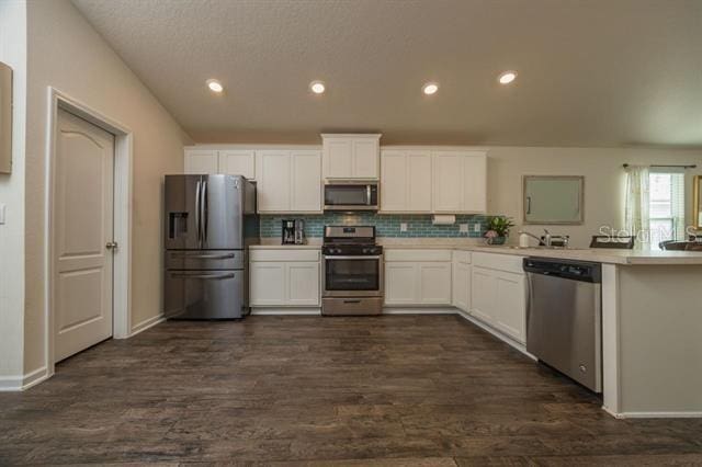 kitchen featuring tasteful backsplash, stainless steel appliances, dark hardwood / wood-style floors, and white cabinets