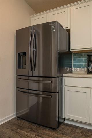 kitchen with white cabinetry, dark hardwood / wood-style floors, stainless steel fridge with ice dispenser, and backsplash