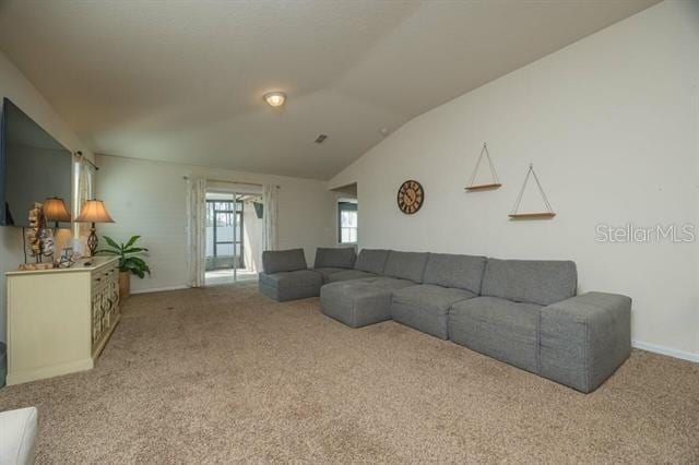 carpeted living room featuring lofted ceiling