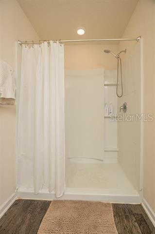 bathroom with hardwood / wood-style floors and a shower with shower curtain