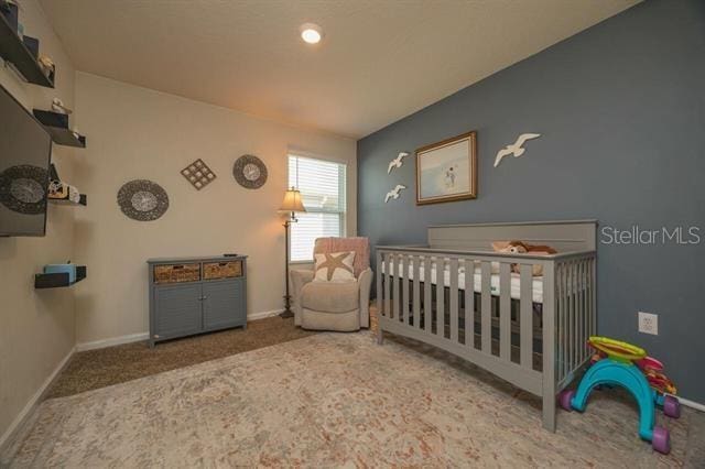 bedroom with carpet and a crib