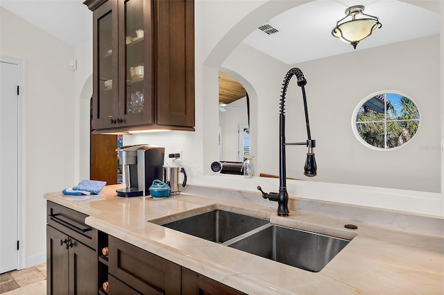 kitchen with a healthy amount of sunlight, dark brown cabinets, and sink