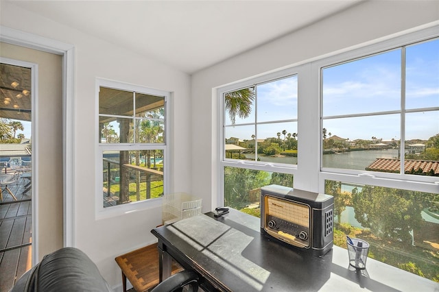 sunroom / solarium with a water view and lofted ceiling