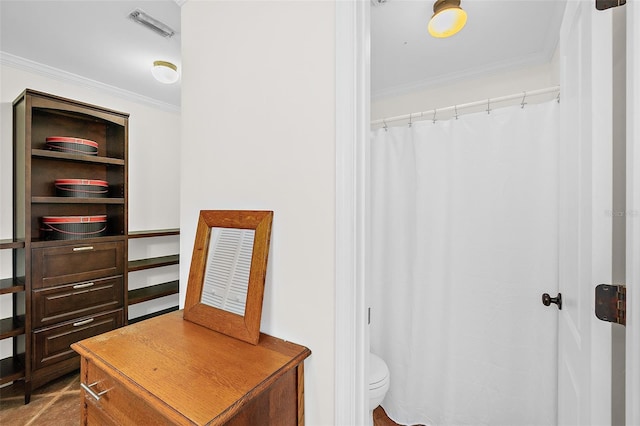 bathroom with crown molding and toilet