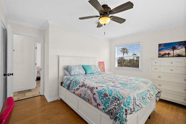 bedroom with ornamental molding, ceiling fan, and light wood-type flooring