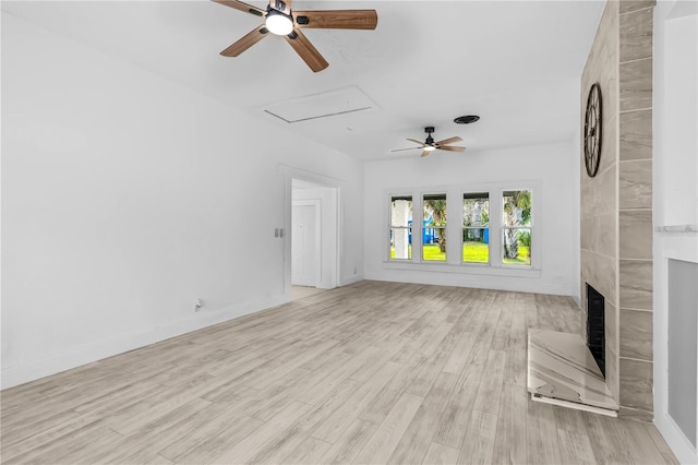 unfurnished living room featuring ceiling fan, a fireplace, and light wood-type flooring