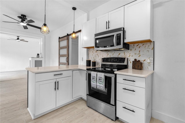 kitchen with white cabinetry, appliances with stainless steel finishes, decorative light fixtures, and backsplash