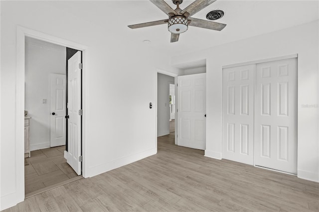 unfurnished bedroom with light hardwood / wood-style flooring, a closet, and ceiling fan