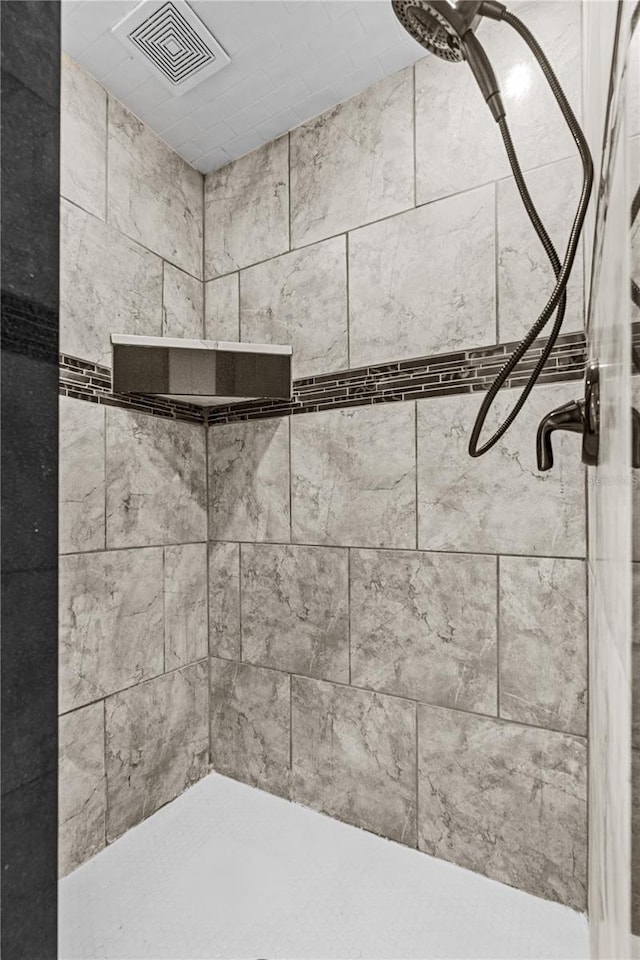interior details with a tile shower
