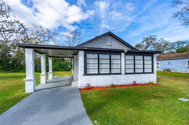 view of side of property featuring a carport and a lawn