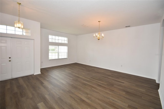 foyer entrance featuring a chandelier, dark wood-style flooring, visible vents, and baseboards