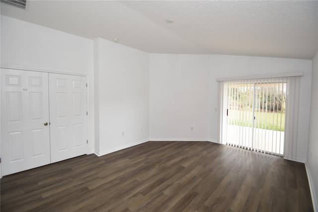 unfurnished room featuring lofted ceiling, dark wood finished floors, visible vents, and baseboards