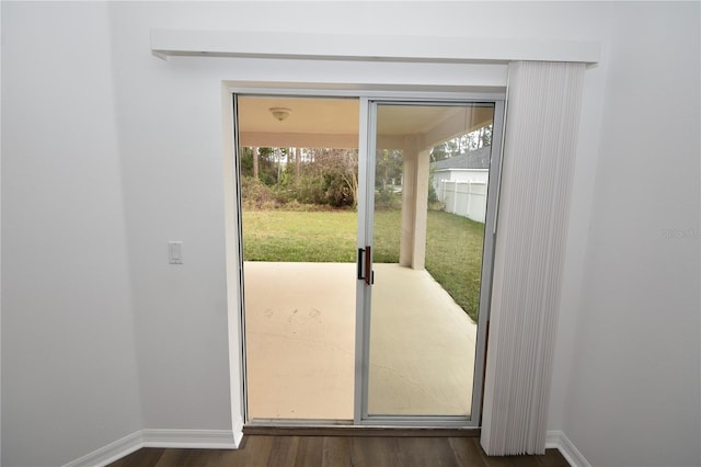 doorway to outside featuring dark wood-type flooring and baseboards