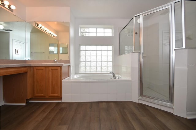 full bath with wood finished floors, a bath, and a healthy amount of sunlight