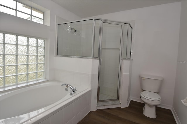 full bathroom with toilet, wood finished floors, baseboards, a shower stall, and a bath