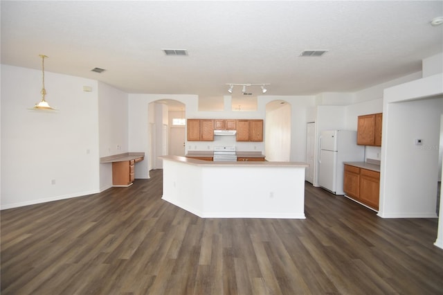 kitchen featuring stove, arched walkways, decorative light fixtures, and freestanding refrigerator