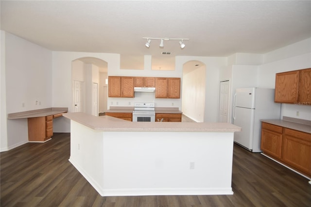 kitchen featuring white appliances, light countertops, and a center island with sink