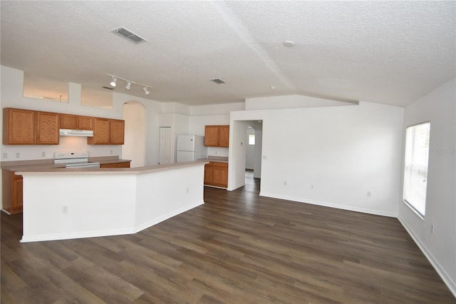 kitchen with brown cabinets, white appliances, light countertops, and a center island