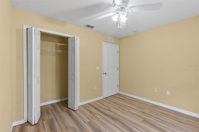 unfurnished bedroom featuring ceiling fan, light wood-type flooring, and a closet